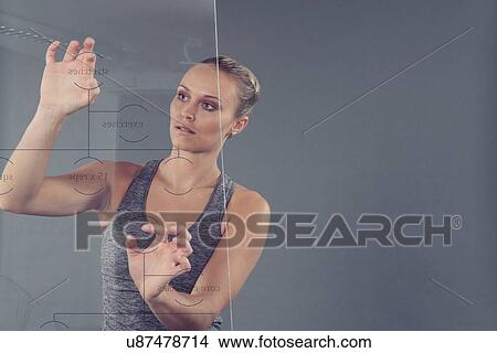 Young woman studying chart on glass wall, grey background View Large Photo Image Picture - Young woman studying chart on glass wall, grey background. Fotosearch