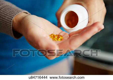 "Young woman taking medication from bottle, close-up" View Large Photo Image Picture - "Young woman taking medication from bottle, close-up". Fotosearch