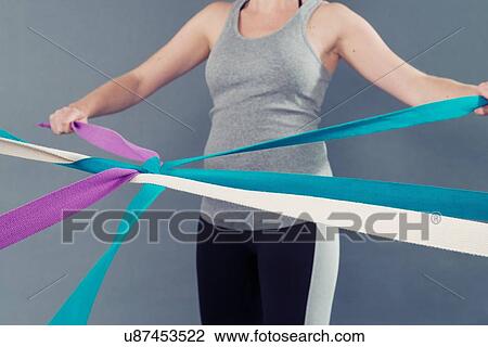 Young woman using coloured bands, grey background View Large Photo Image Stock Image - Young woman using coloured bands, grey background. Fotosearch