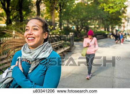 Young woman walking and smiling in park View Large Photo Image Stock Photograph - Young woman walking and smiling in park. Fotosearch