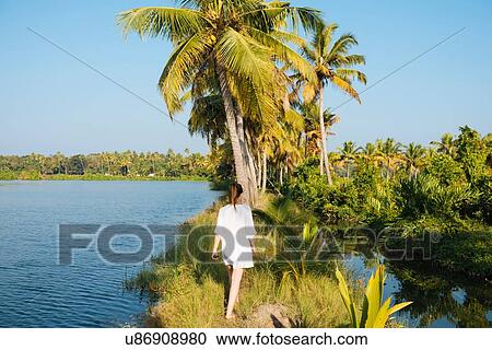 Stock Image - Young woman walking at Karela Backwaters near North Paravoor, Kerala, India. Fotosearch