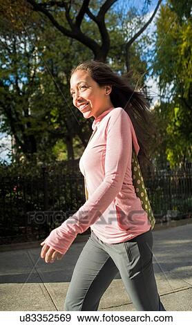 Young woman walking in park View Large Photo Image Stock Photo - Young woman walking in park. Fotosearch