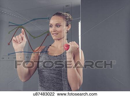 Young woman with dumbbell studying chart on glass wall, grey background View Large Photo Image Stock Image - Young woman with dumbbell studying chart on glass wall, grey background. Fotosearch