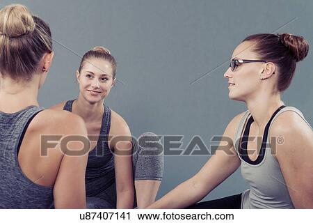 Young women chatting, grey background View Large Photo Image Stock Image - Young women chatting, grey background. Fotosearch