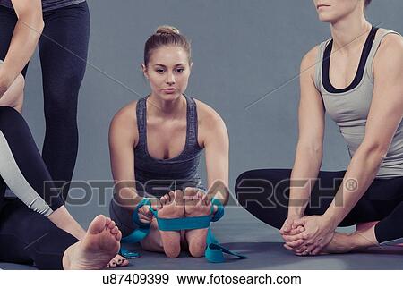 Young women doing stretching exercise, grey background View Large Photo Image Stock Photo - Young women doing stretching exercise, grey background. Fotosearch