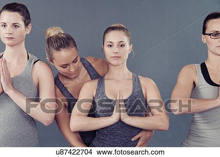 Young women practising yoga, grey background View Large Photo Image Picture - Young women practising yoga, grey background. Fotosearch