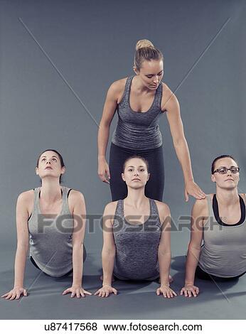 Young women practising yoga, grey background View Large Photo Image Stock Photo - Young women practising yoga, grey background. Fotosearch