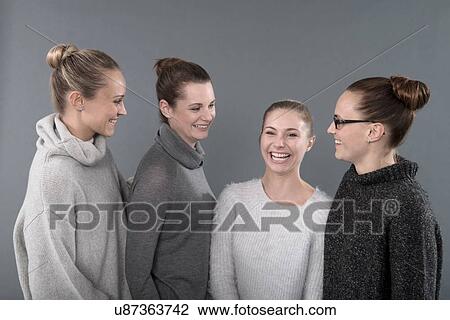 Stock Image - Young women smiling, grey background. Fotosearch