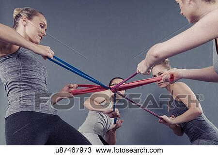 Young women using coloured bands, grey background View Large Photo Image Stock Image - Young women using coloured bands, grey background. Fotosearch