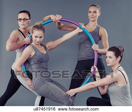 Young women using hula hoop, grey background View Large Photo Image Stock Photograph - Young women using hula hoop, grey background. Fotosearch