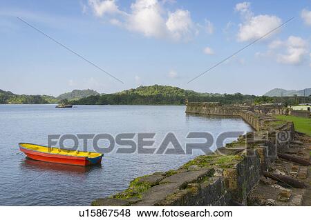 Boat on bay moored by stone wall View Large Photo Image Stock Photo - Boat on bay moored by stone wall. Fotosearch