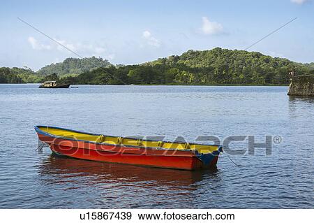 Stock Photo - Boat on bay with green hills in background. Fotosearch