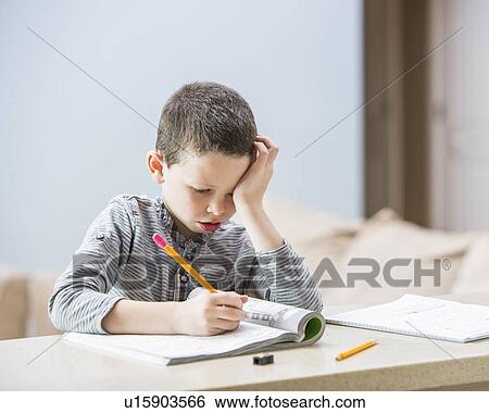 Boy (6-7) doing homework View Large Photo Image Stock Photograph - Boy (6-7) doing homework. Fotosearch