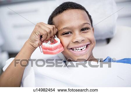 Picture - Boy holding dentures. Fotosearch