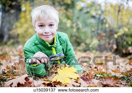 Stock Photo - Boy holding magnifying glass. Fotosearch