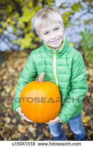 Boy holding pumpkin View Large Photo Image Stock Photo - Boy holding pumpkin. Fotosearch