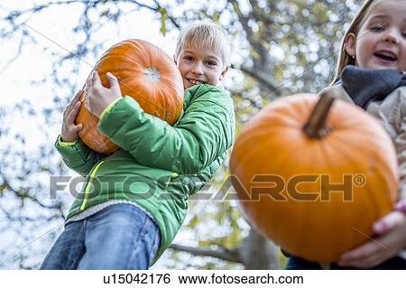 Stock Photograph - Children carrying pumpkins. Fotosearch