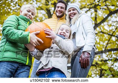Stock Image - Children holding pumpkin. Fotosearch