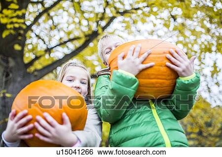 Children holding pumpkin View Large Photo Image Stock Photograph - Children holding pumpkin. Fotosearch