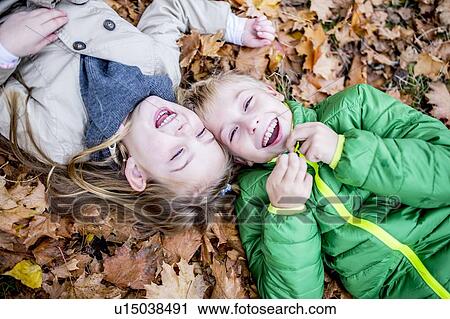 Children lying on dried leaves View Large Photo Image Stock Image - Children lying on dried leaves. Fotosearch
