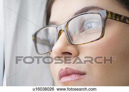 Close up of young woman with blue eyes wearing glasses View Large Photo Image Stock Photograph - Close up of young woman with blue eyes wearing glasses. Fotosearch