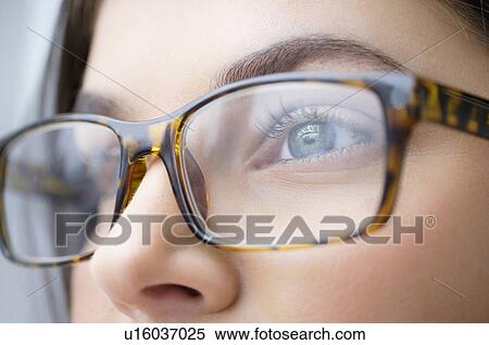 Stock Photography - Close up of young woman with blue eyes wearing glasses. Fotosearch