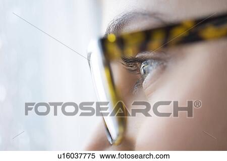 Stock Photography - Close up of young woman with blue eyes wearing glasses. Fotosearch