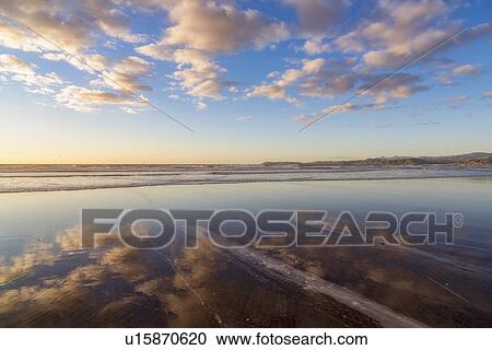 Stock Image - Cloudy sky reflected in sea. Fotosearch