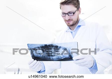 Stock Image - Dentist and assistant holding x-ray. Fotosearch