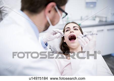 Picture - Dentist anesthetizing patient. Fotosearch