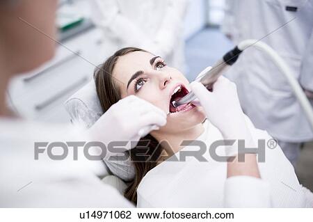 Stock Image - Dentist examining patient. Fotosearch