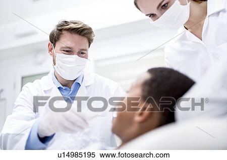 Stock Photography - Dentist examining patient. Fotosearch