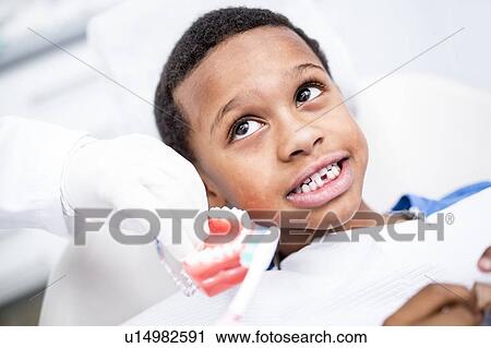 Dentist showing dentures to boy View Large Photo Image Stock Image - Dentist showing dentures to boy. Fotosearch