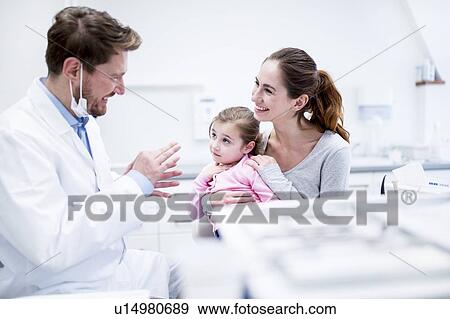 Stock Photo - Dentist talking with patient. Fotosearch