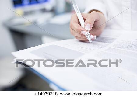 Stock Photo - Dentist writing on file. Fotosearch