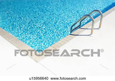 Stock Image - Edge of empty swimming pool in sunlight. Fotosearch