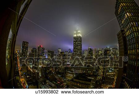 Stock Image - Empire State Building shrouded in night fog. Fotosearch