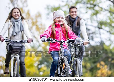 Stock Image - Family cycling together. Fotosearch