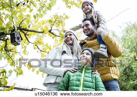 Stock Photograph - Family in park smiling together. Fotosearch