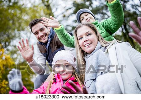 Stock Image - Family waving hands, portrait. Fotosearch
