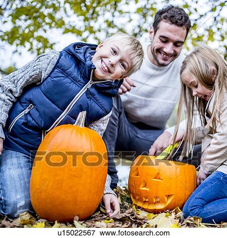 Stock Photo - Family with Halloween pumpkin. Fotosearch