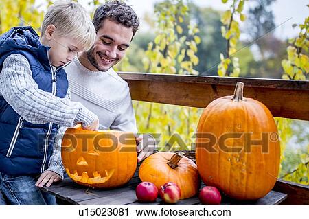 Stock Image - Father and son with Halloween pumpkin. Fotosearch