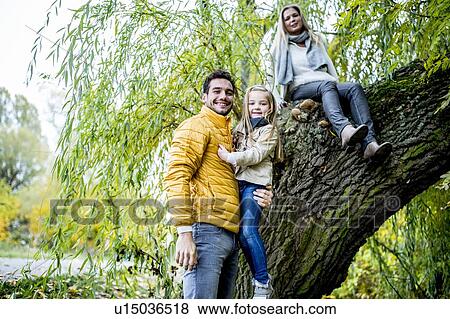 Father carrying daughter near tree View Large Photo Image Stock Photo - Father carrying daughter near tree. Fotosearch