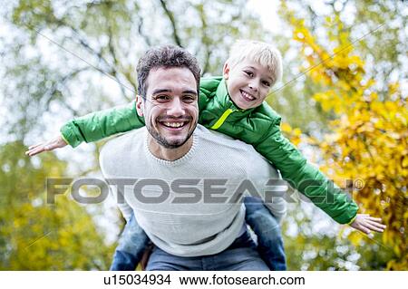 Picture - Father carrying son on his back. Fotosearch