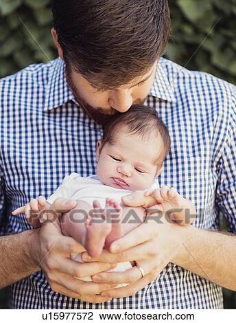 Stock Image - Father holding and kissing daughter (2-5 months). Fotosearch