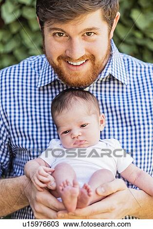 Stock Image - Father holding daughter (2-5 months). Fotosearch