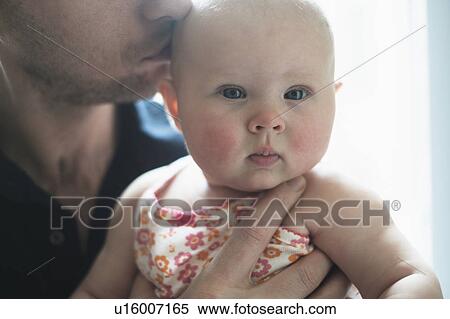 Stock Photography - Father kissing daughter's (2-5 months) head. Fotosearch