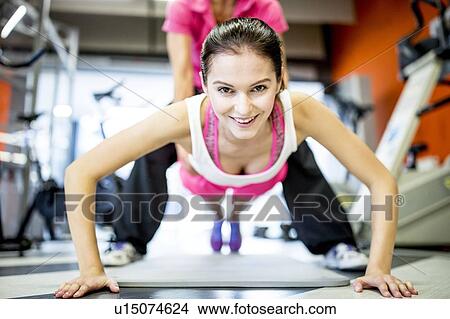 Fitness trainer helping woman View Large Photo Image Picture - Fitness trainer helping woman. Fotosearch