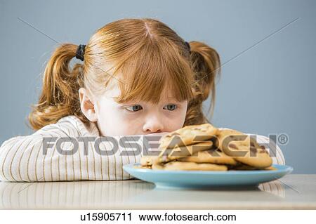 Girl (4 -5) looking on plate of cookies View Large Photo Image Stock Image - Girl (4 -5) looking on plate of cookies. Fotosearch