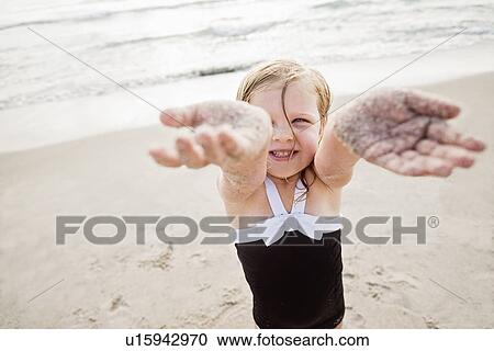 Girl (4-5) standing on beach showing her dirty hands View Large Photo Image Stock Image - Girl (4-5) standing on beach showing her dirty hands. Fotosearch